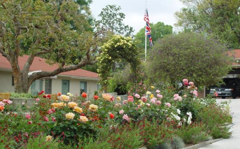Senior living community in California with lush gardens, houses, and a British flag.