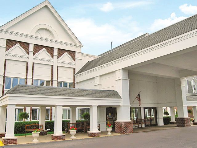 Senior living community architecture, The Fountains at Crystal Lake, featuring housing, hotel-style buildings, portico, and benches.