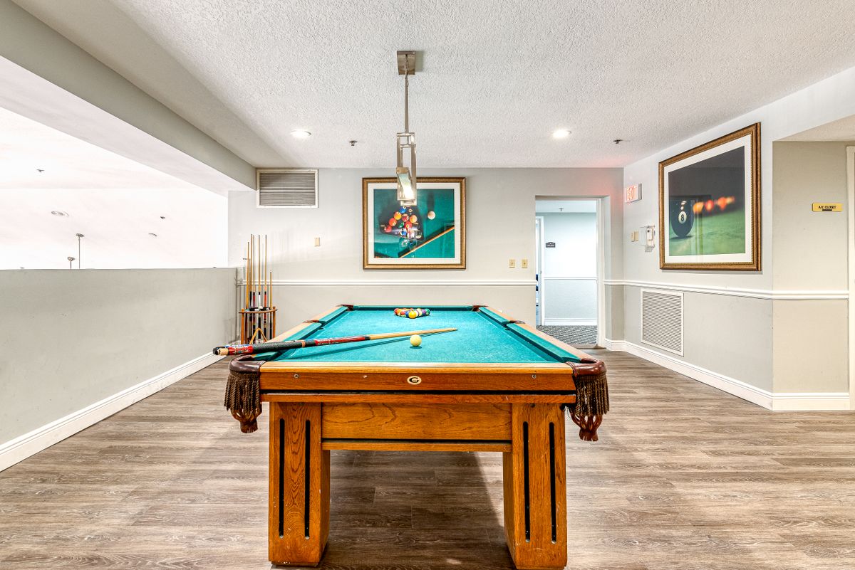 Senior living community room at The Meridian At Lantana with furniture, art, and pool table.