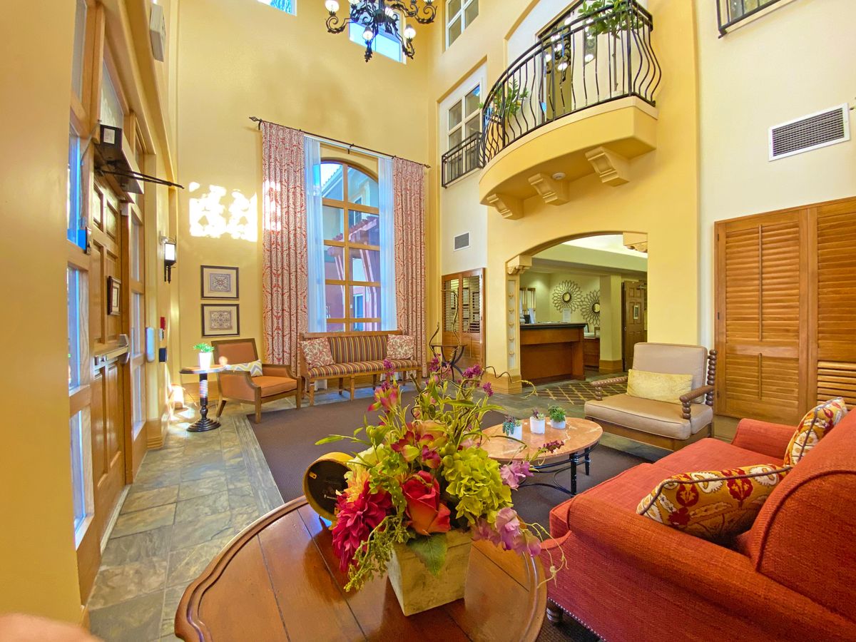 Senior living room interior at AlmaVia of Camarillo with elegant furniture, art, and flower decor.
