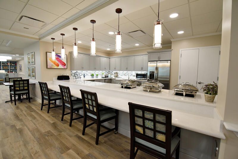 Interior view of The Monarch senior living community featuring dining area, kitchen island, and modern architecture.