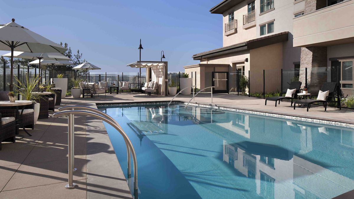 Belmont Village Senior Living Aliso Viejo featuring resort-style pool, waterfront patio, and villa housing.