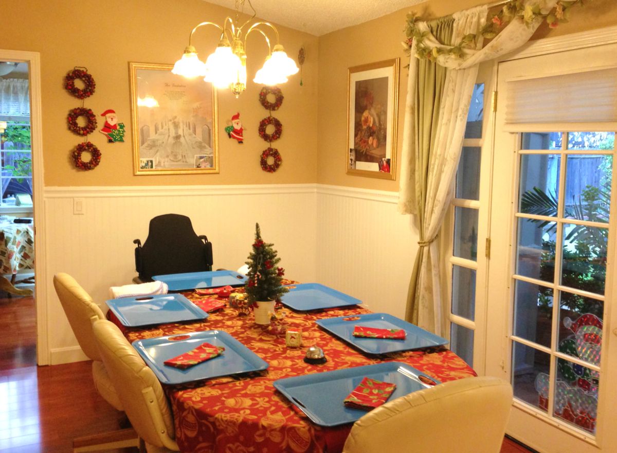 Senior living community Care A Lot featuring elegant dining room with wooden furniture and home decor.
