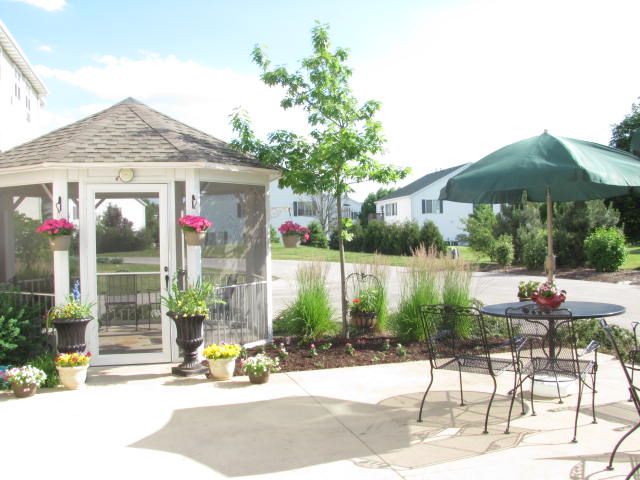 Senior living community, Heritage Woods of South Elgin, featuring patio, garden, and nature views.