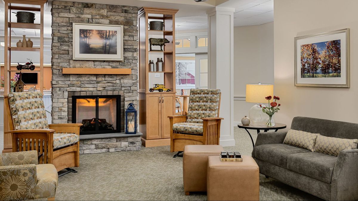 Interior view of Bridges® By Epoch At Sudbury senior living community featuring a cozy fireplace.