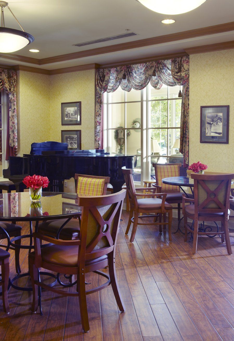 Senior living community Ivy Park at Woodland Hills featuring elegant dining room with piano.