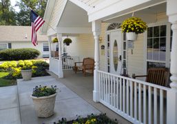 Arden Courts Of Silver Spring senior living community featuring a porch with potted plants.