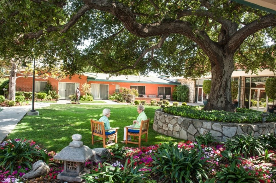 Senior living community Royal Oaks with lush gardens, park-like setting, and elegant architecture.