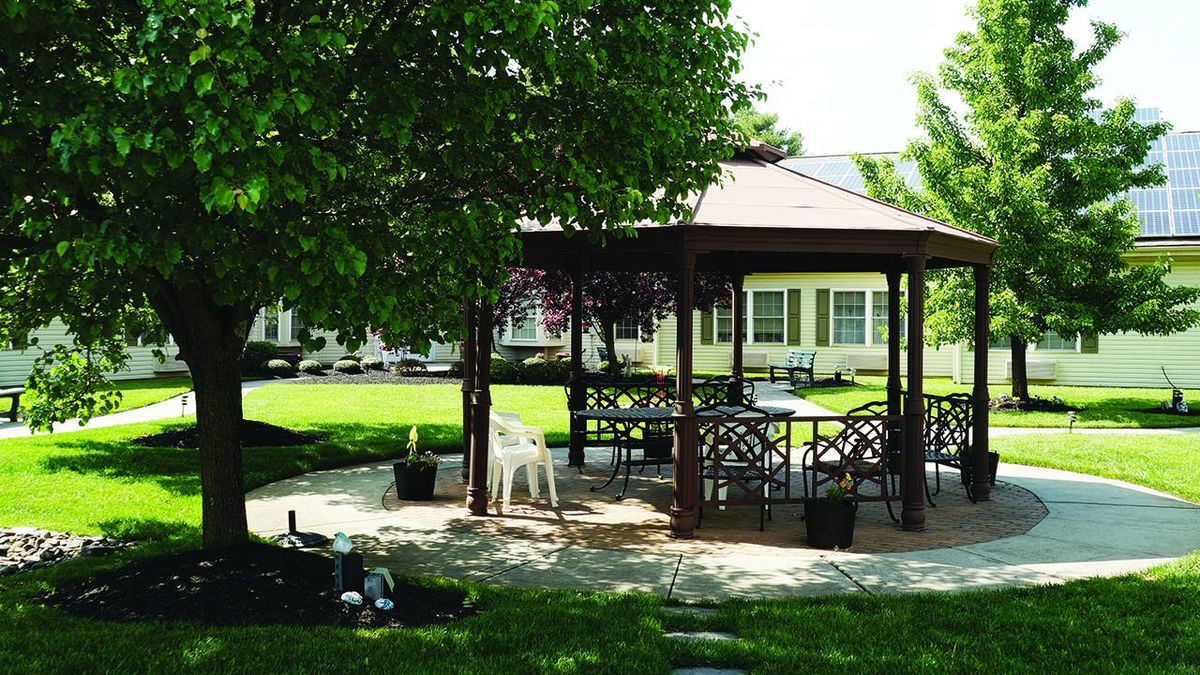 Greenfield Senior Living at Cross Keys featuring a park-like yard with gazebo and outdoor furniture.