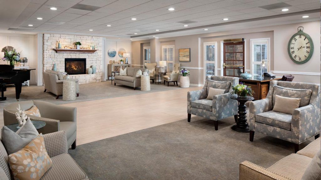 Senior living room at Belmont Village Cardiff By The Sea with piano, furniture, and fireplace.