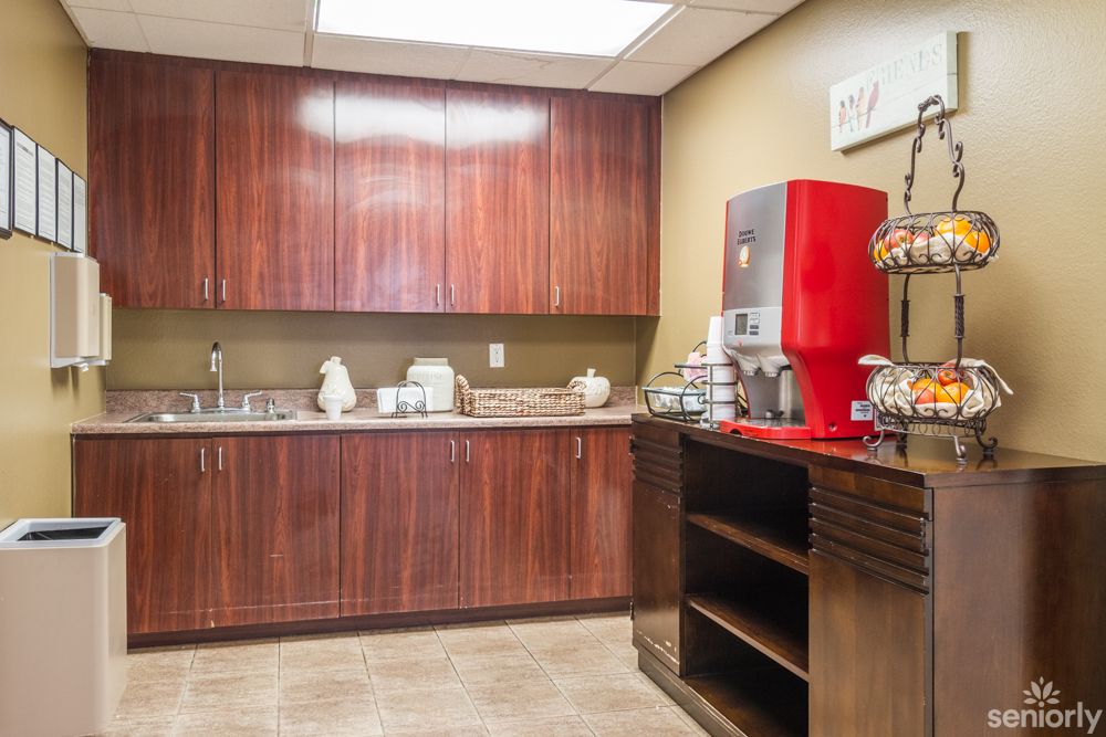 Senior resident in Glen Terra Assisted Living's well-designed kitchen with hardwood flooring and appliances.