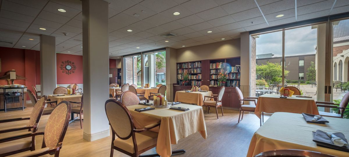 Interior view of Chateau de Notre Dame Assisted Living featuring dining area, library, and lounge.