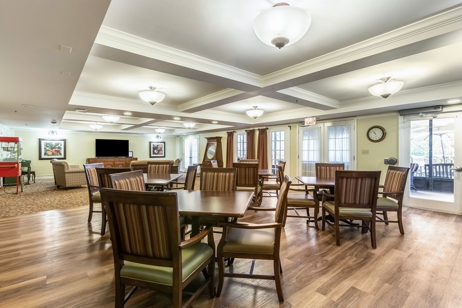 Interior view of Grand Villa of Sarasota senior living community featuring dining area and lounge.