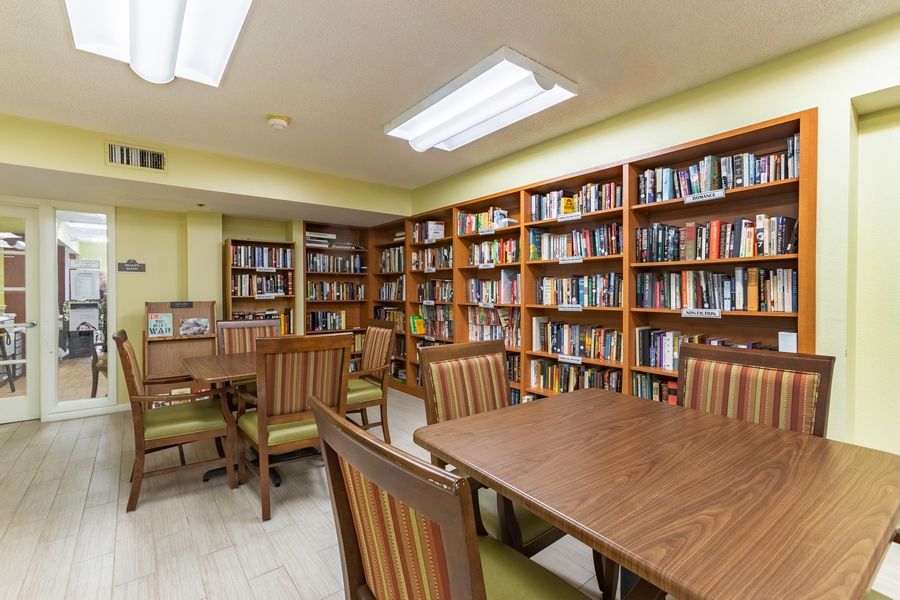 Interior view of Grand Villa of Sarasota's library with wooden furniture and bookcases.