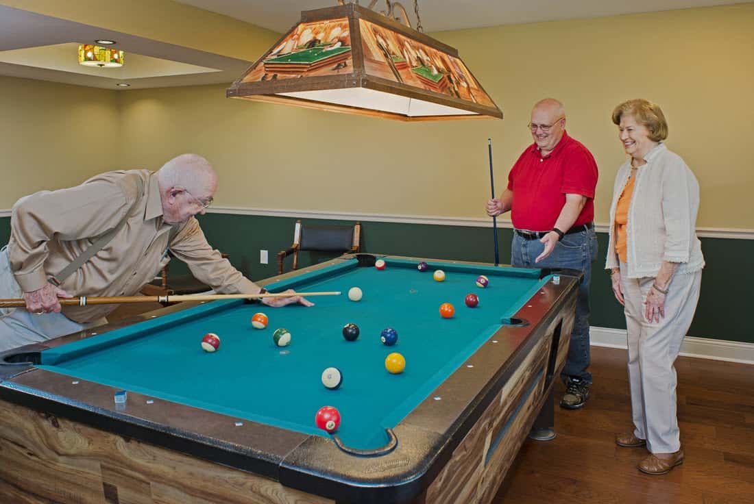 Senior man playing billiards at Asbury Place, a Kingsport senior living community.