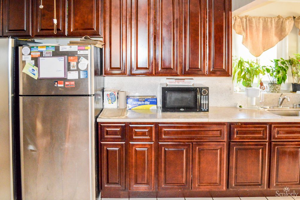 Senior resident in a well-equipped kitchen with modern appliances at Heritage Hills.