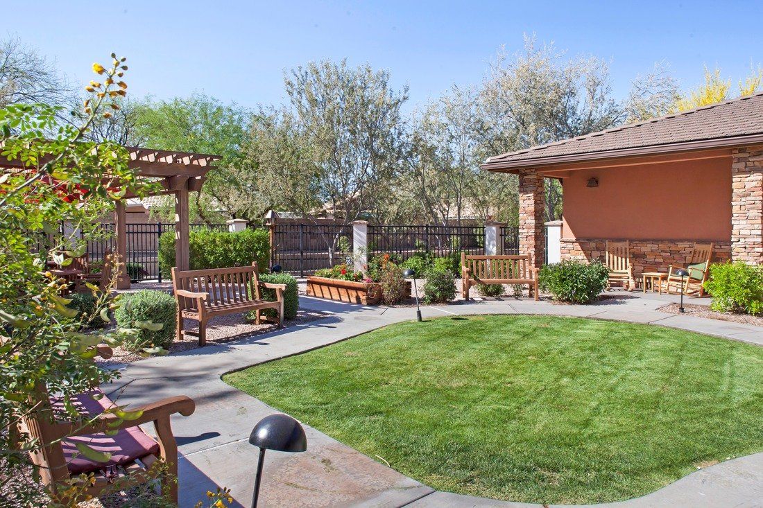 Senior living community in Chandler with lush gardens, outdoor furniture, and modern architecture.