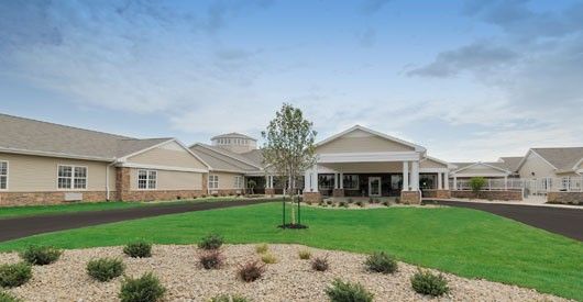 Shelby Crossing Health Campus, a senior living community with lush lawns and modern architecture.
