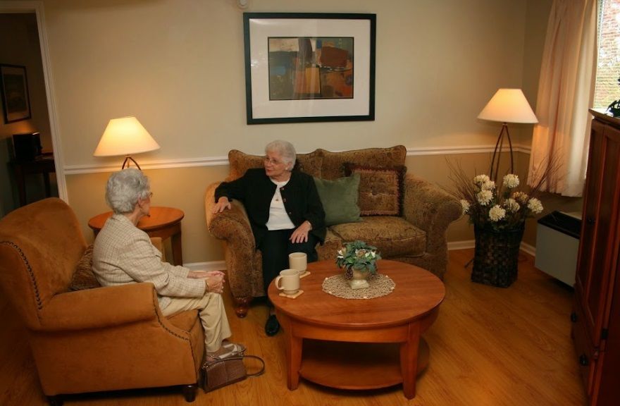 Senior man in suit relaxing in the luxurious living room of Premier Cadbury senior living community in Cherry Hill.