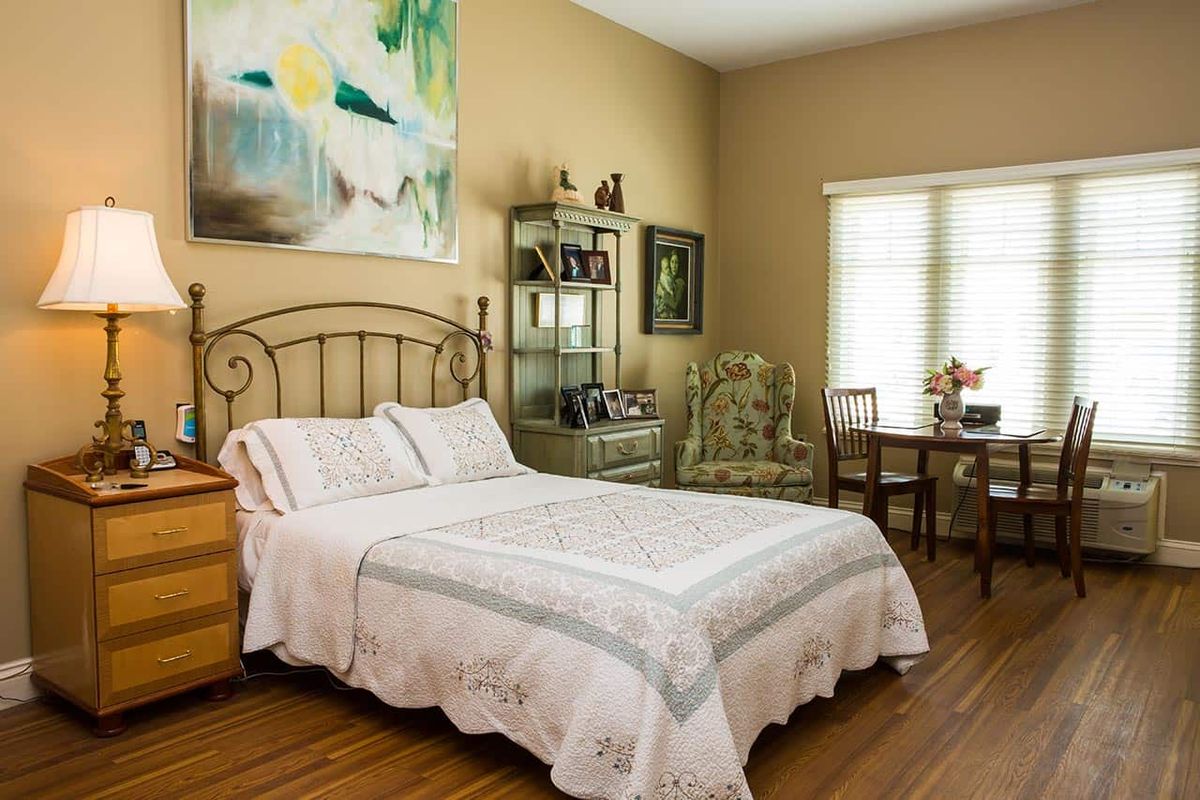 Senior living community bedroom interior at The Glen, featuring furniture, art, and home decor.