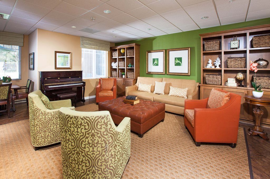 Interior view of Raincross at Riverside senior living community featuring a piano, furniture, and decor.