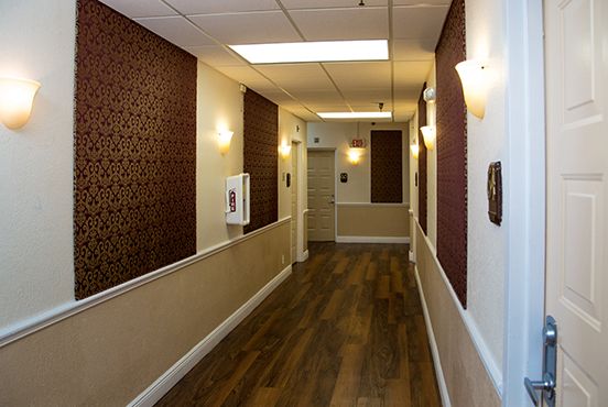 Interior view of Courtyard Plaza senior living community featuring wood flooring and corridor design.
