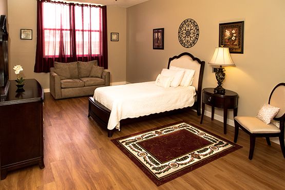 Interior design of a senior living room at Courtyard Plaza featuring hardwood floors and cozy furniture.