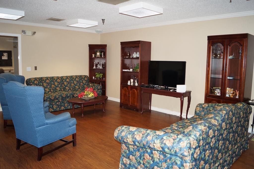 Senior living room interior at Cleveland House with modern decor, electronics, and residents.