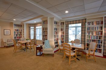 Interior view of Goddard House senior living community featuring a library, living and dining room.