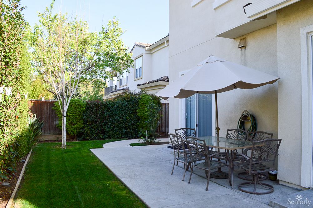 Senior living community, Lifeshare Care Home 3, featuring lush lawns, patio dining, and modern architecture.