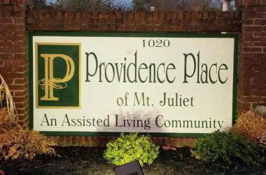 Providence Place of Mt. Juliet senior living community with lush vegetation, brick architecture, and signage.