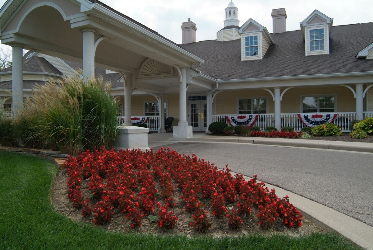Senior living community, Spring Hills Middletown, featuring lush lawns, trees, and modern architecture.