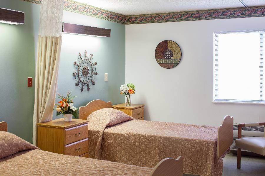 Bedroom interior at Willow Ridge Senior Living Center featuring cozy furniture and home decor.