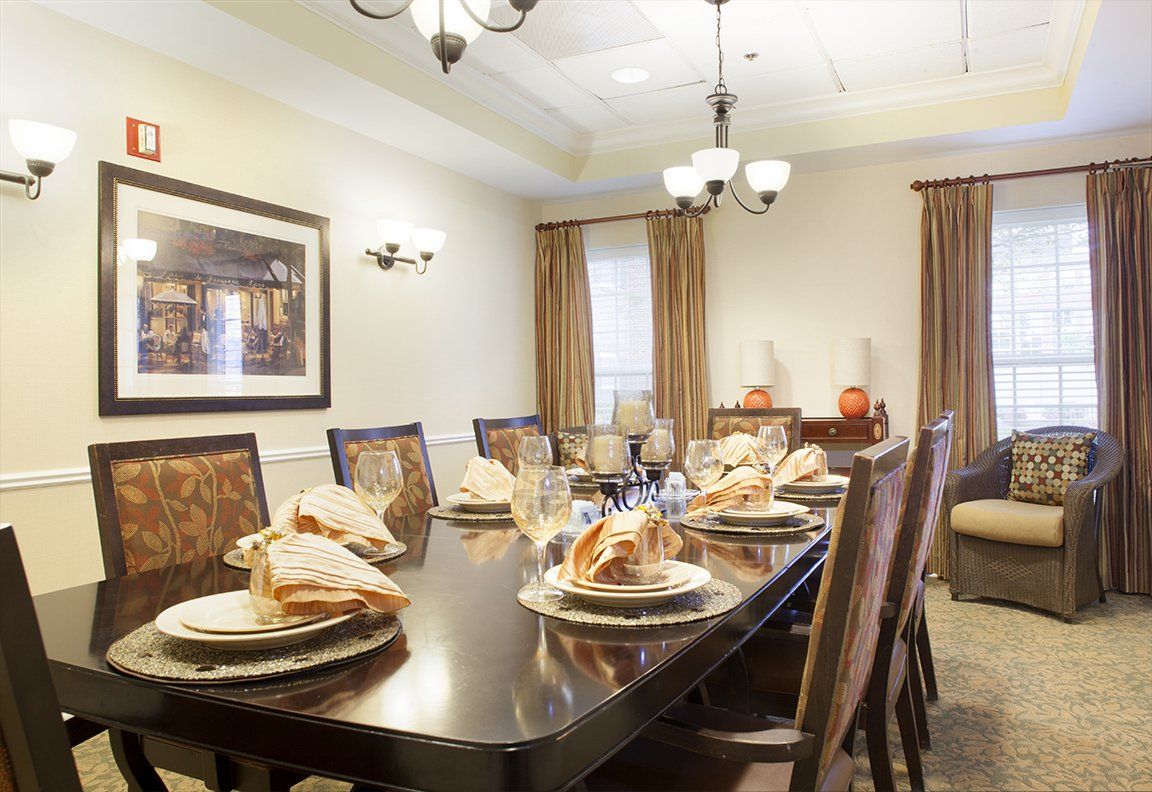 Senior living community Brighton Gardens of Brentwood featuring dining room with table setup, food and decor.