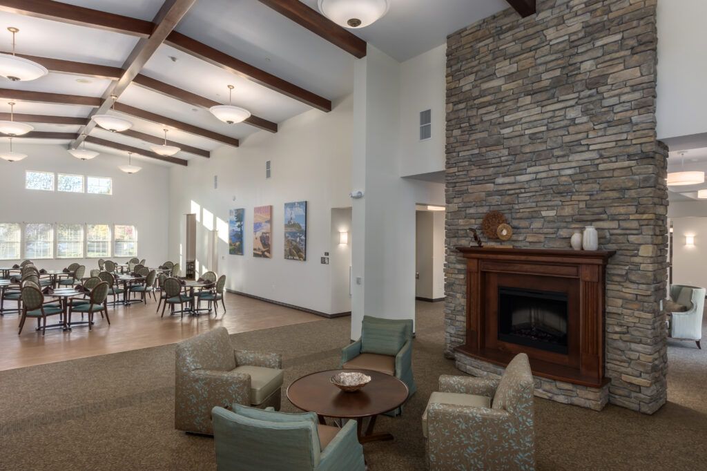 Interior view of CountryHouse at Granite Bay senior living community featuring a cozy fireplace, stylish furniture, and dining area.