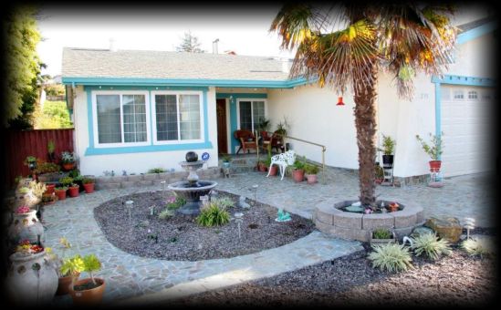 Senior living community, Hercules Home, featuring a villa with a lush garden, patio, and outdoor furniture.