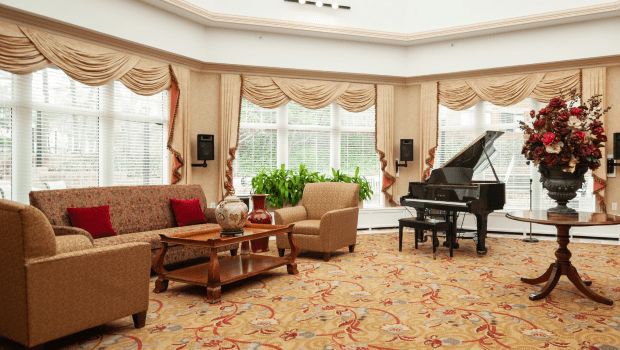 Senior living room interior at Five Star Premier Residences of Teaneck with grand piano and decor.