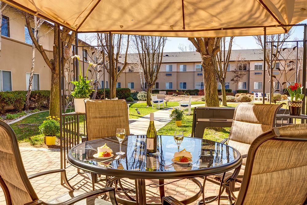 Senior living community Creston Village featuring patio dining, lush outdoors, and cozy interior design.