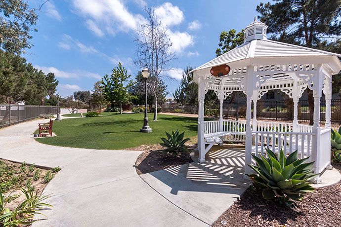 Silverado Encinitas senior living community featuring lush greenery, park, gazebo, and patio.