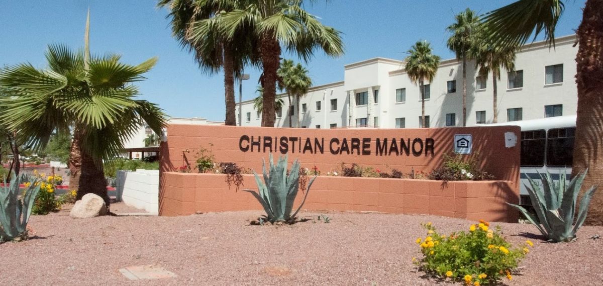 Christian Care Manor IV, a senior living community with lush vegetation and urban amenities.