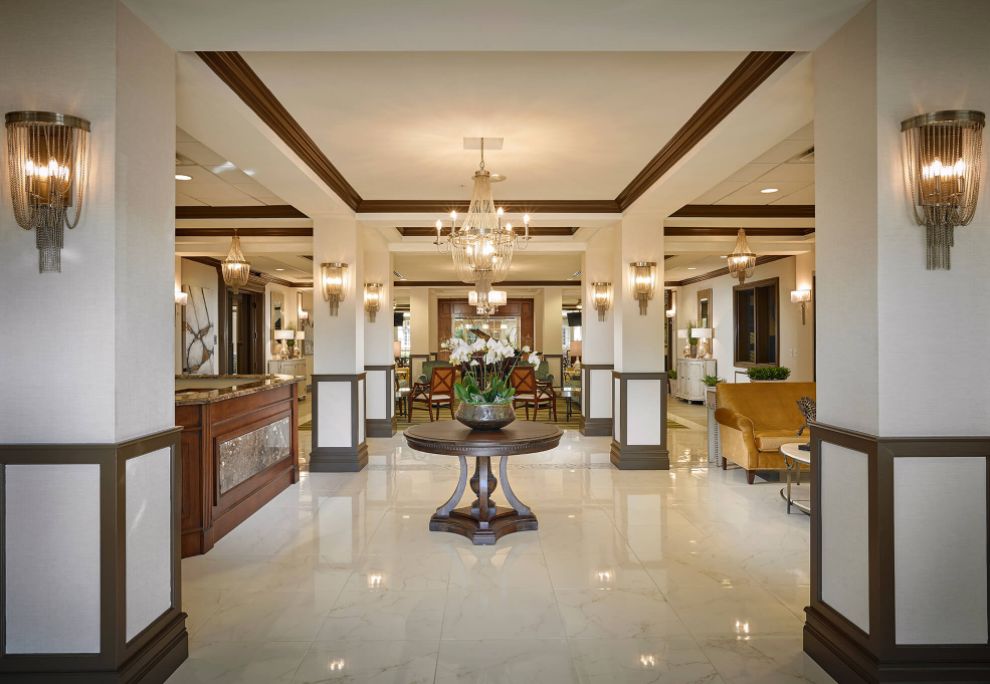 Interior view of Oakmonte Village Of Davie senior living community featuring dining room, chandelier, and architecture.
