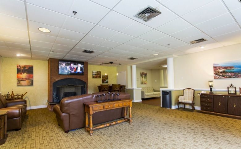 Senior resident enjoying TV in a well-decorated reception room at Fountains at Cedar Parke.
