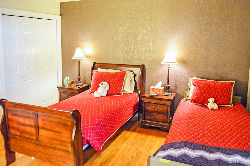 Interior view of a cozy bedroom in Harvy's Home Care senior living community with wooden furniture.