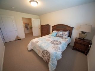 Corner bedroom with bed and furniture in Villas Of Holly Brook Herrin senior living community.