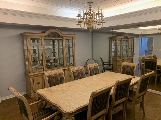 Interior view of Rosecastle At Delaney Creek senior living community featuring dining room with elegant furniture and chandelier.