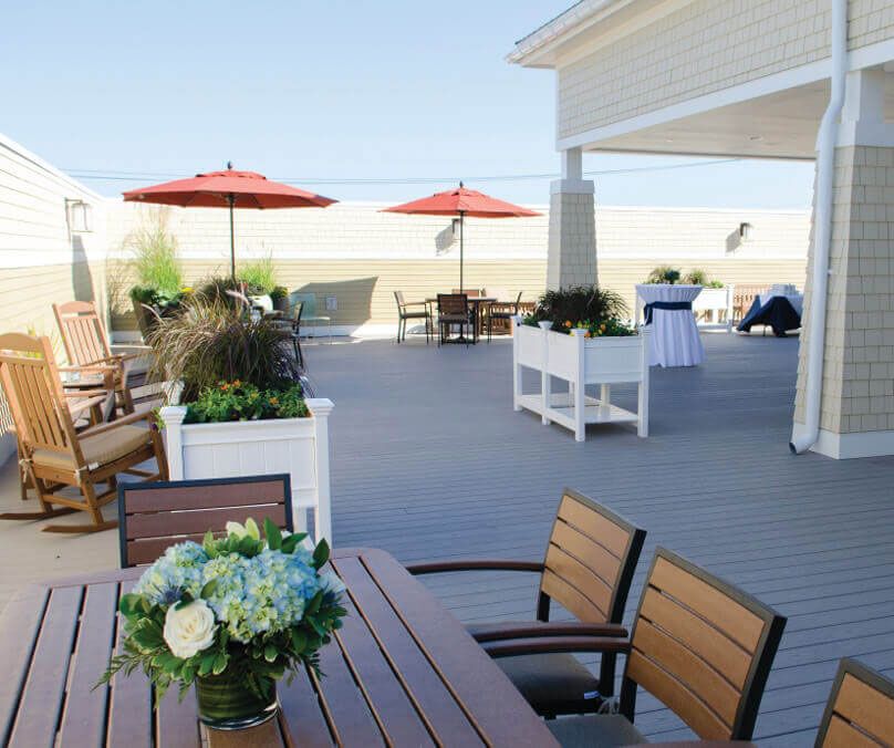 Senior living community, Bridges® By Epoch At Norwalk, featuring indoor patio with furniture and plants.