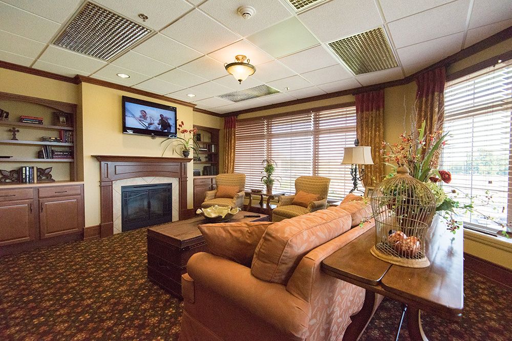 Senior living room interior at Garden Plaza of Florissant featuring modern decor, electronics, and plants.