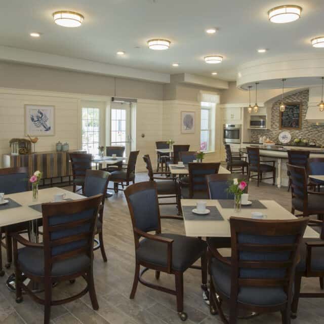 Senior living community dining area at Cornerstone At Hampton featuring art, furniture, and appliances.