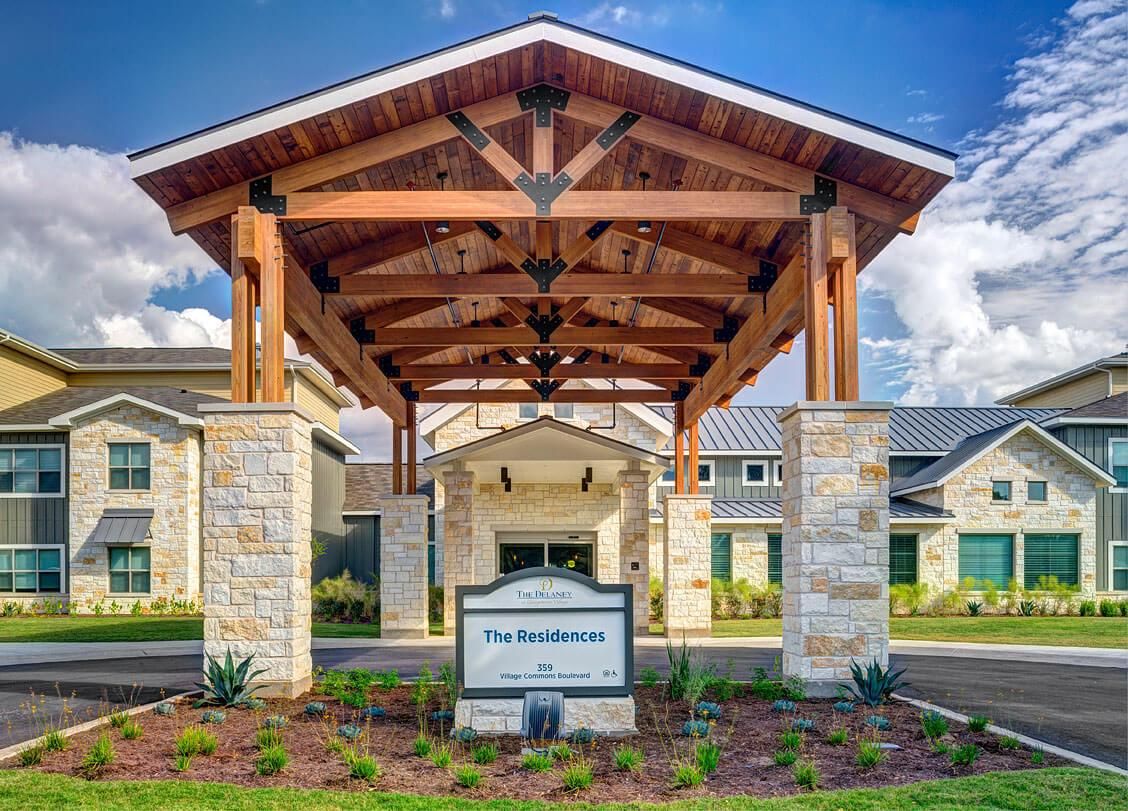 Exterior view of The Delaney at Georgetown Village senior living community with portico.