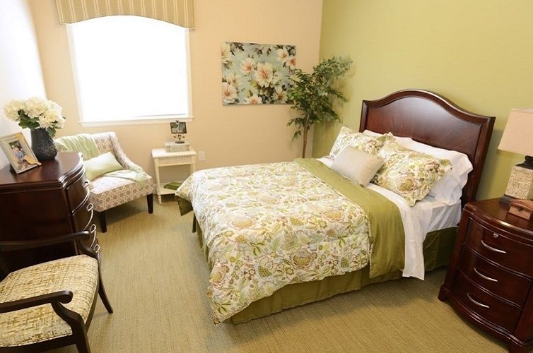 Senior living community bedroom at Bader House of Georgetown featuring art, furniture, and home decor.